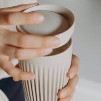 Hands around a ribbed cup