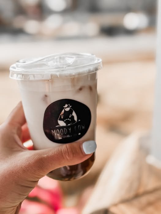Iced latte held to camera
